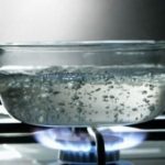 Boiling water in a glass pot on a gas stove, illustrating safe drinking water practices and the effectiveness of boiling against viruses.