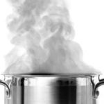 Metallic cooking pot with steam, emphasizing kitchen maintenance tips from Marc Francis Plumbing for preventing sink clogs.