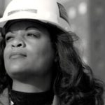 A woman wearing a hard hat, representing Adrienne Bennett, the first Black female master plumber in the U.S.