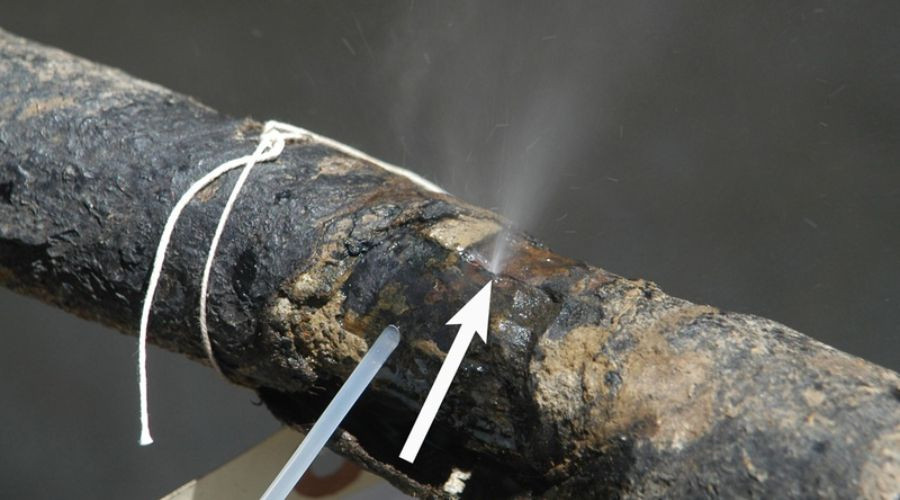 Wooden artifact showing deterioration with an arrow pointing to moisture; related to plumbing insights.