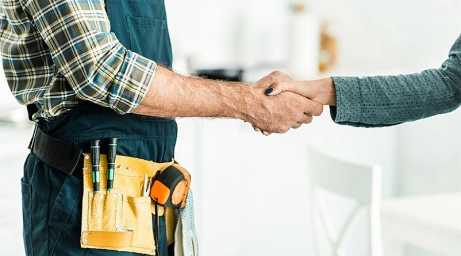 Two individuals in casual attire shake hands, symbolizing professionalism in plumbing services by Marc Francis Plumbing.