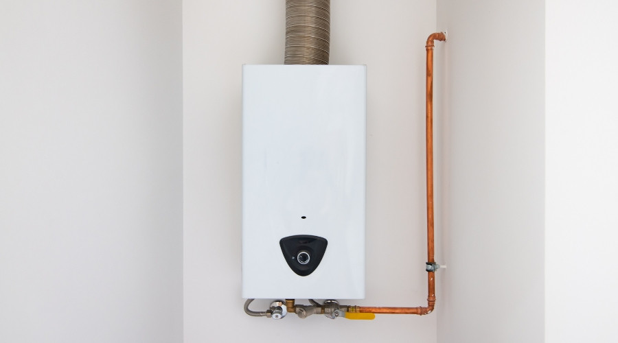 Tankless water heater mounted on a wall with copper piping and venting, illustrating plumbing maintenance and installation services.