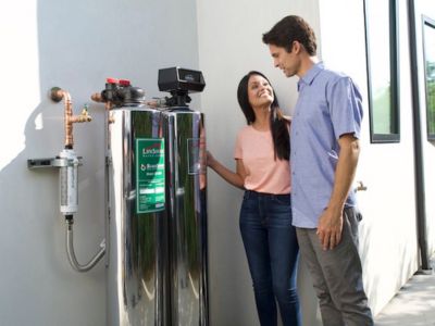 Couple discussing a water softener system, showcasing the benefits of water softening for hard water issues in homes.