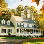 Two-story yellow house surrounded by trees, showcasing a welcoming porch, emphasizing home safety and winter plumbing preparation.