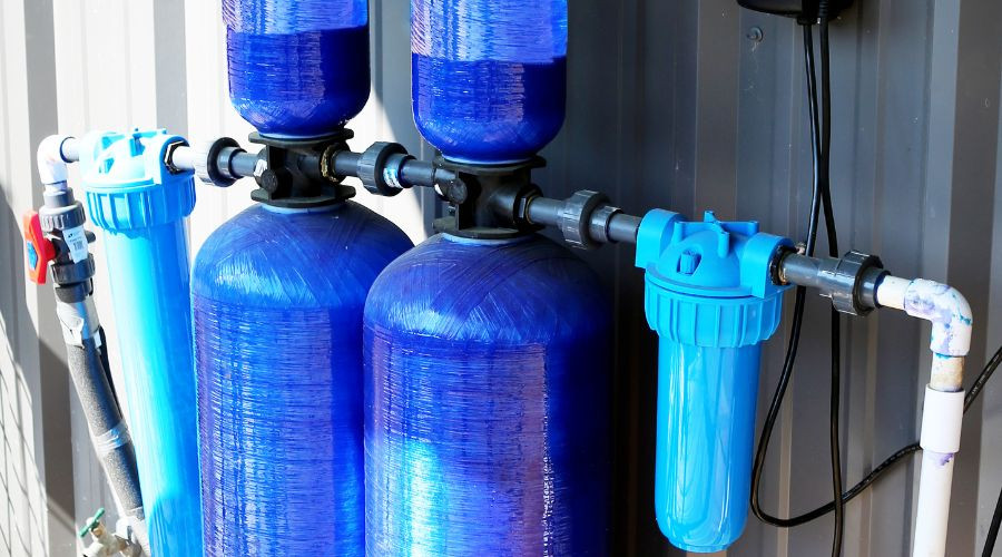 Blue water filtration tanks and pipes highlight Marc Francis Plumbing's efficient water management solutions.